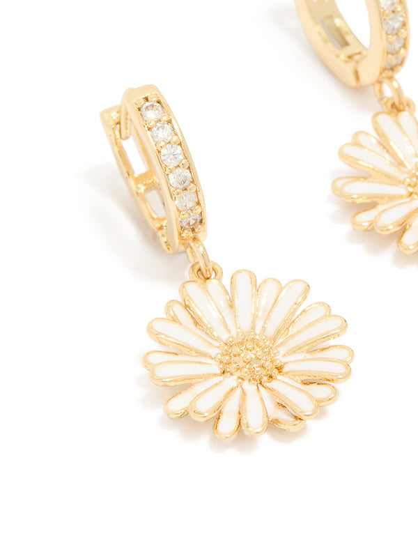 Highlighting statement floral huggie earrings crafted from gold plated materials, featuring white enamel petals and cubic zirconia details close up view