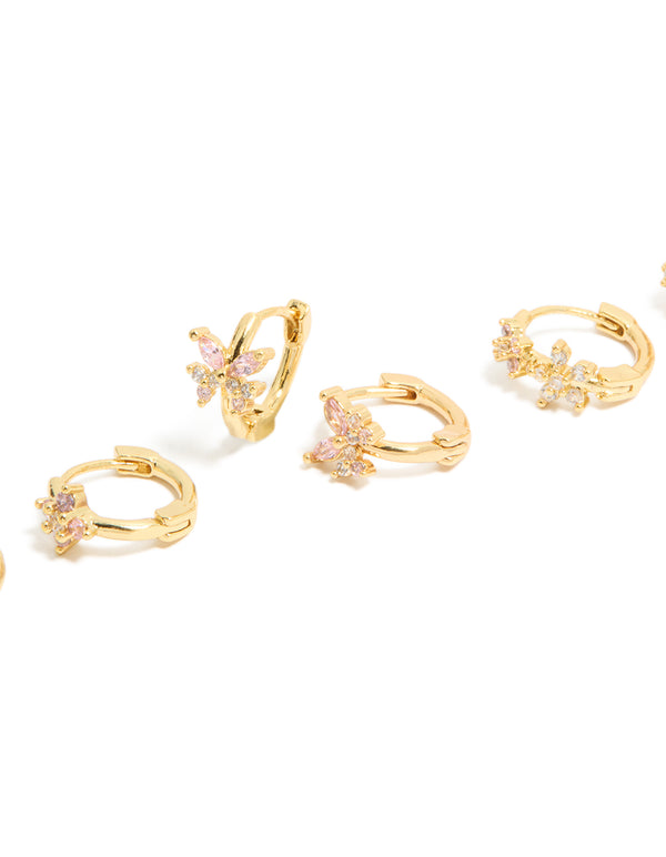 Featuring floral cubic zirconia gold plated huggie earrings in a 3-pack with clear and hot pink accents close up view