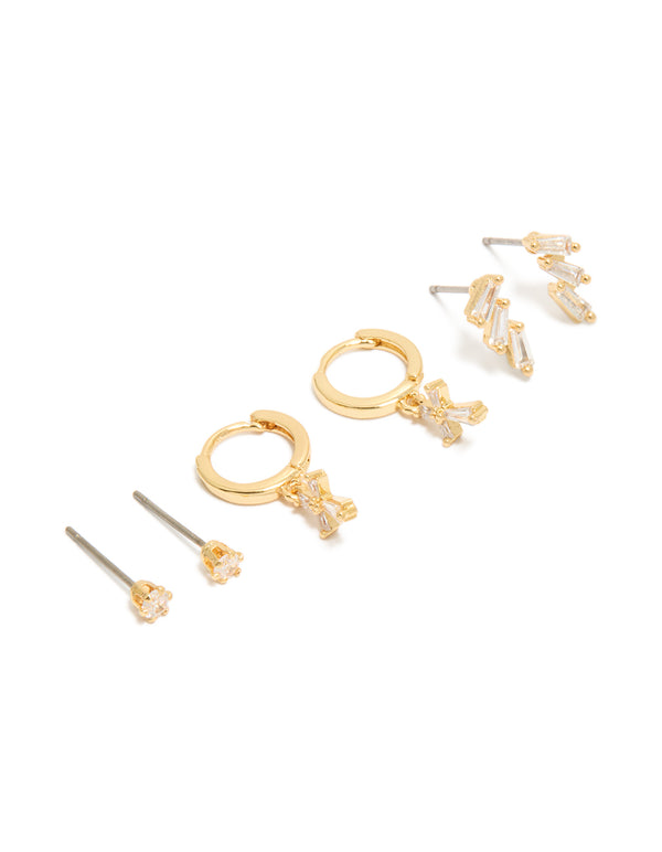 Showcasing dainty charm and cross huggie with trio baguette studs crafted from gold plated cubic zirconia in a 3-pack front view