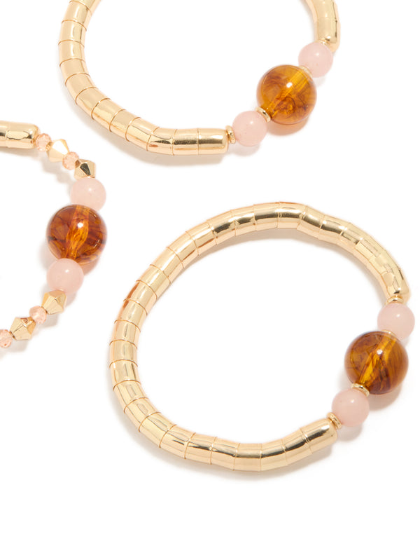Showcasing beaded resin stretch bracelets in a 3-pack with gold and brown tones close up view