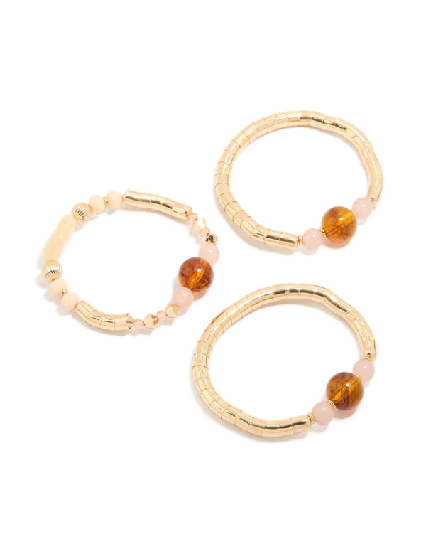 Featuring beaded resin stretch bracelets in a 3-pack with gold and brown tones front view