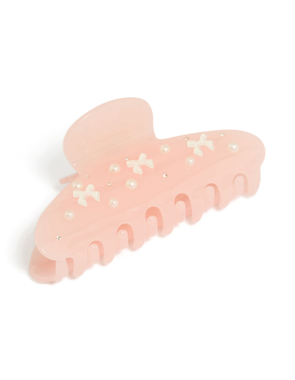 Showcasing a tweens hair claw clip with bow, pearl, and charm accents in solid pink, ivory, and white front view