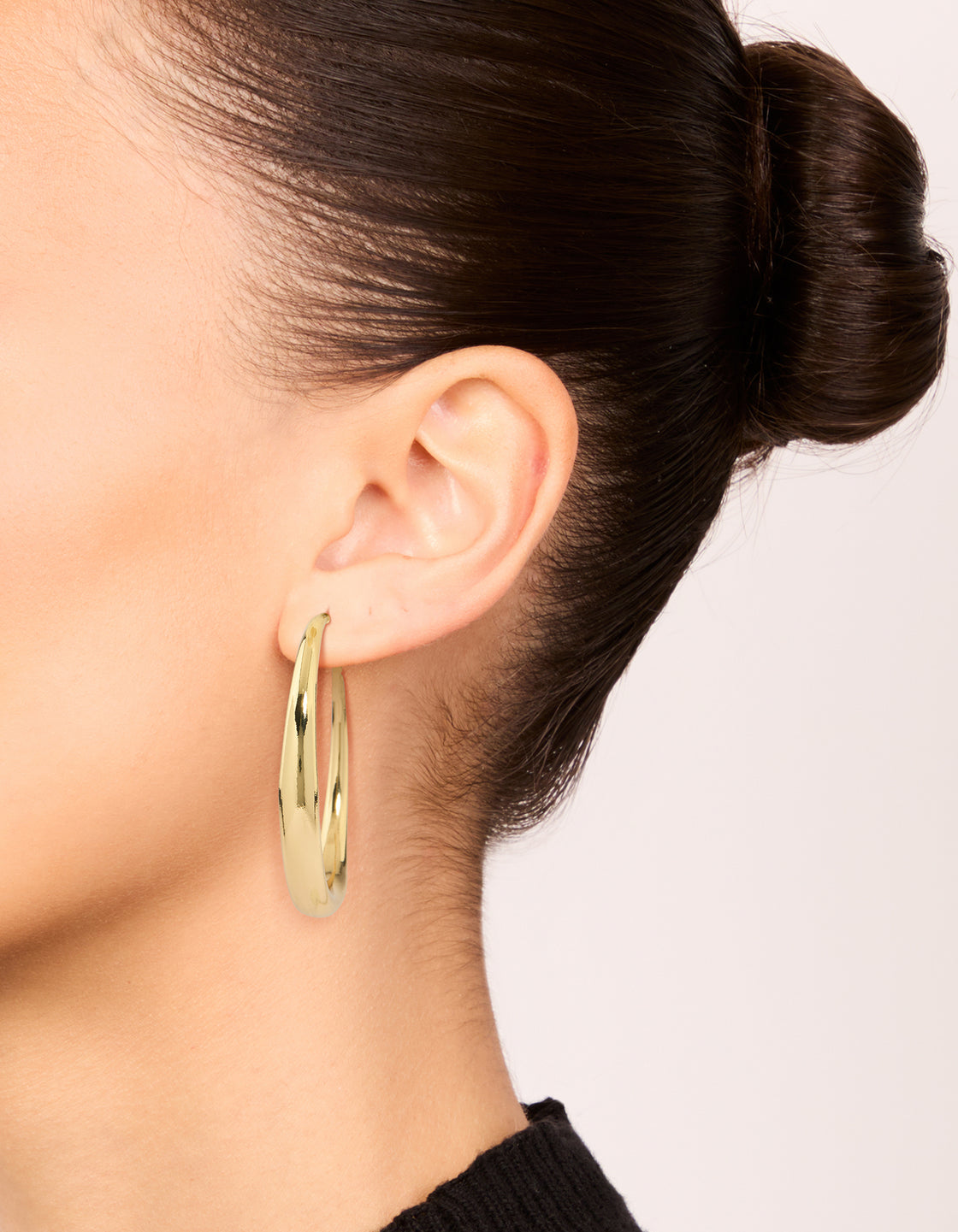 Crafted from gold plated medium hoop earrings with closure on ear view