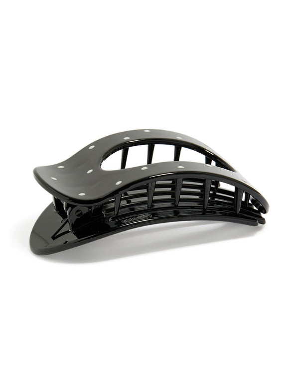 Showcasing a glossy oval claw clip with polkadot print in black and white front view