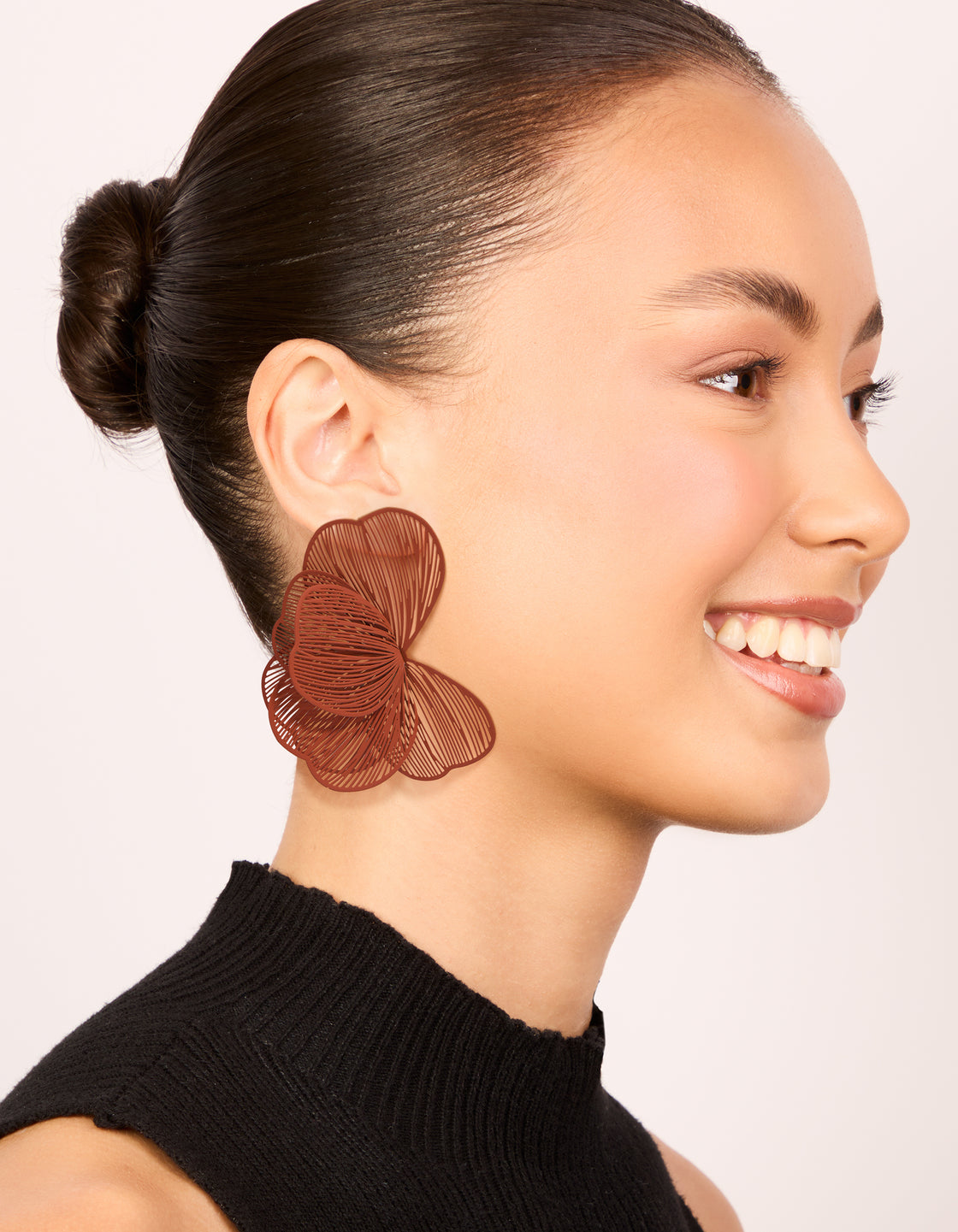 Crafted coated wire orange petal stud earrings with floral design in sienna on model view