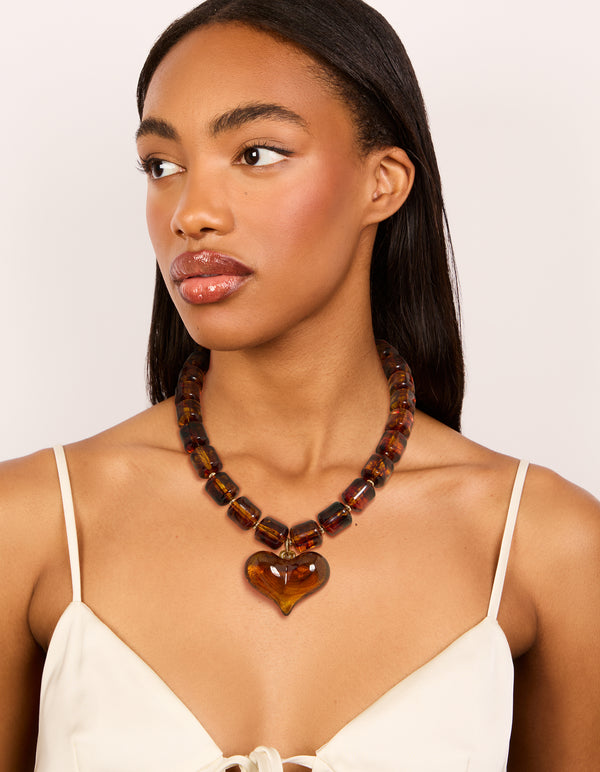 Crafted with brown square beads and a heart necklace in gold tones on model view