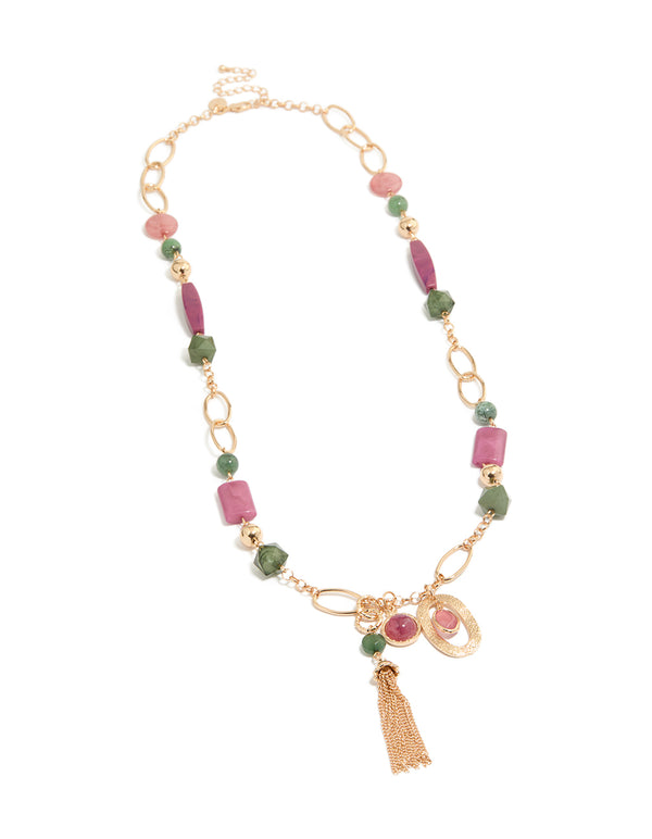 Featuring a gold pink and green acrylic beaded long fringe necklace with charm tassel in statement style front view