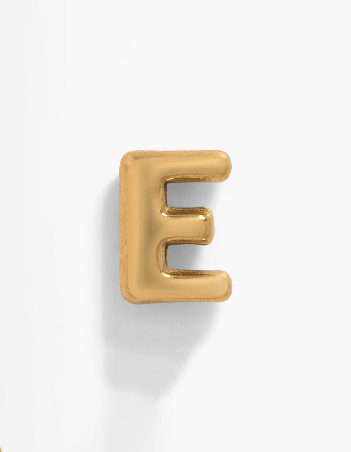 Showcasing a gold plated titanium letter E single threadless flat back stud featuring initials in a front view