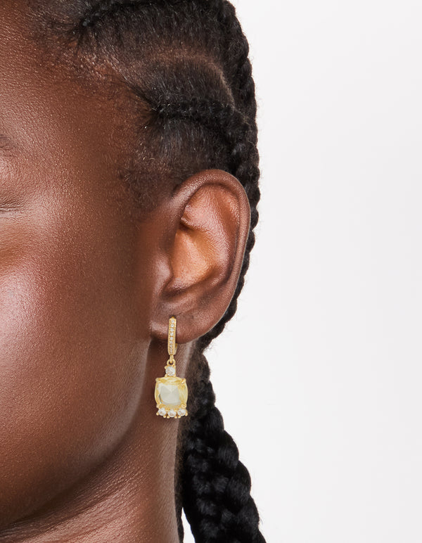 Elegant gold plated cubic zirconia yellow square drop huggie earrings with hoop closure in clear on ear view