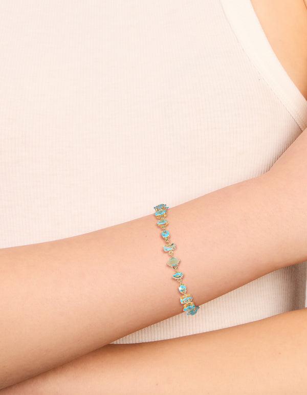 Featuring a gold plated blue large multi cut cubic zirconia tennis bracelet with blue stones and statement design on wrist view