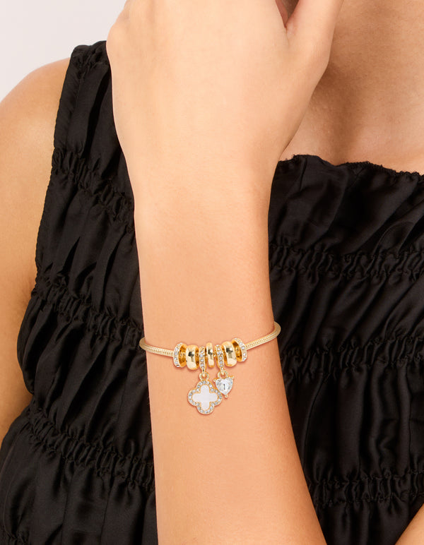 Elegant gold plated cubic zirconia flower and heart toggle bracelet featuring floral charm details on wrist view