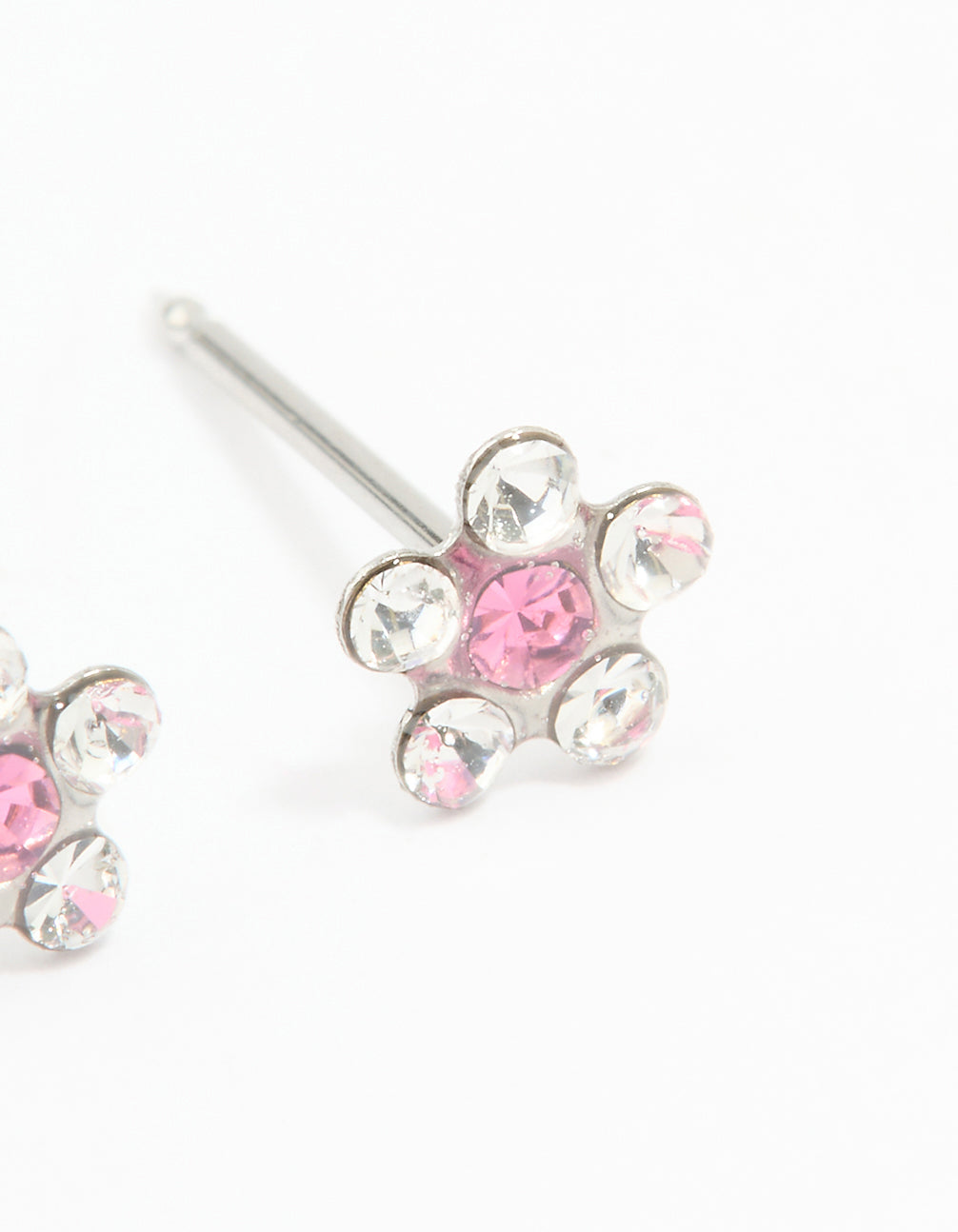 Dainty floral stud piercing earrings featuring pink and clear cubic zirconia set in surgical stainless steel close up view