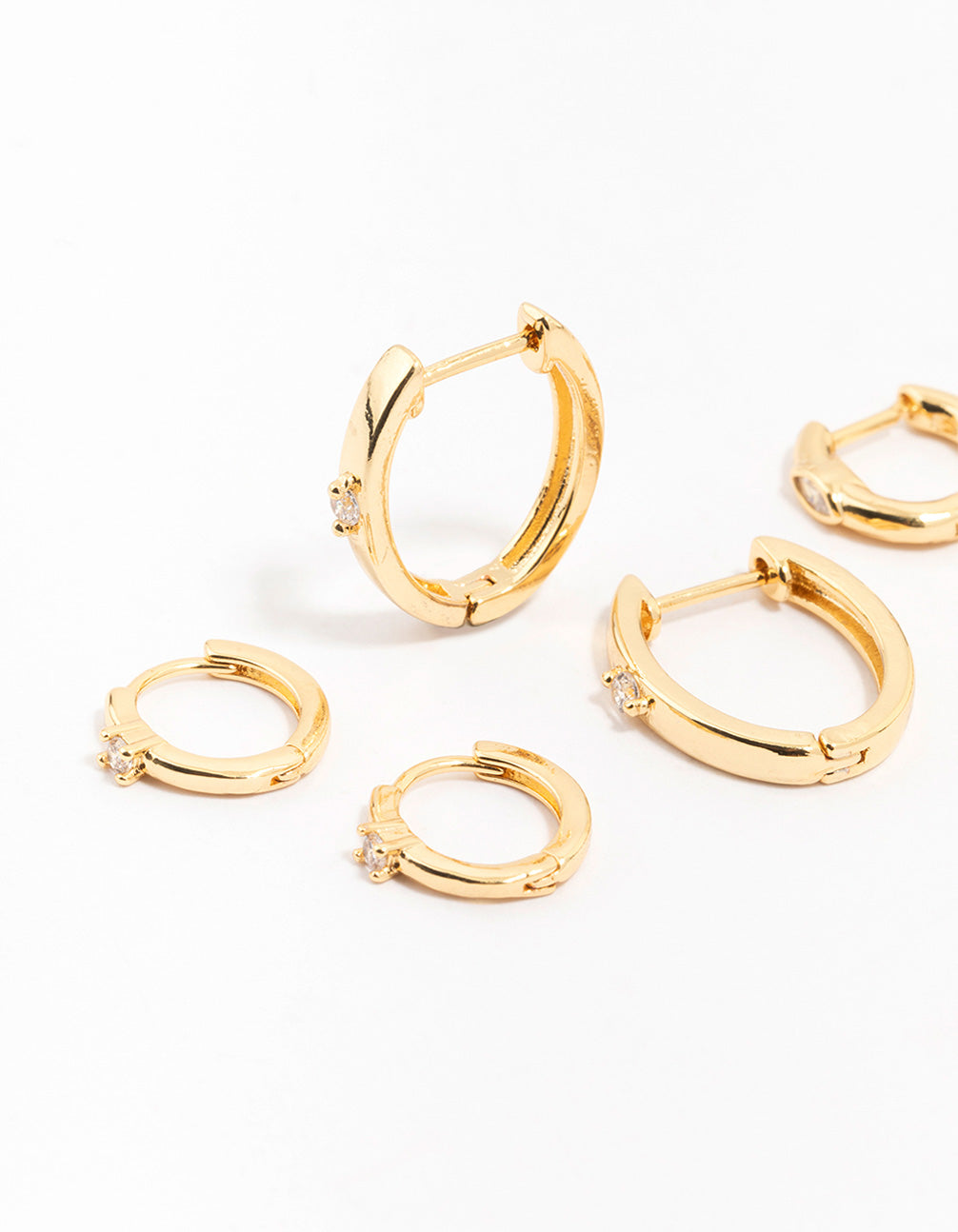 Featuring gold plated brass graduating cubic zirconia earrings with hoop closure close up view