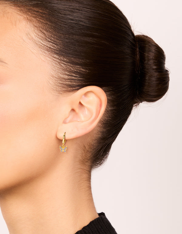 Showcasing gold plated sterling silver cubic zirconia butterfly earrings in purple on ear view