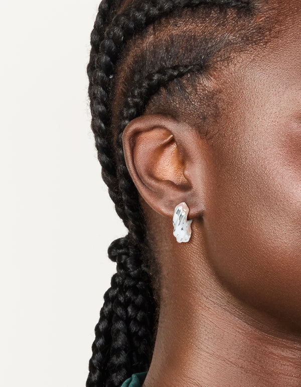 Featuring silver plated twisted hoop earrings with statement design on ear view