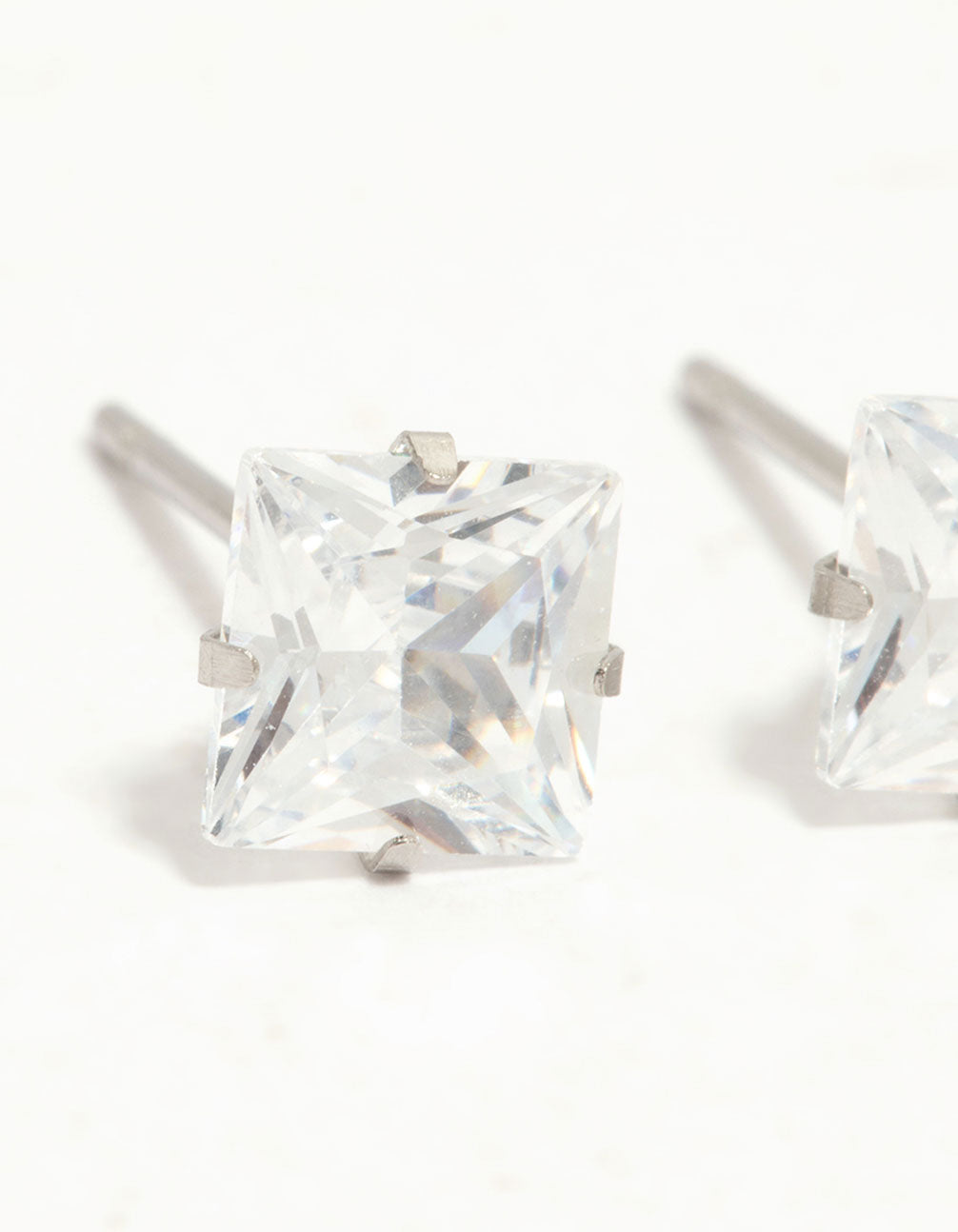 Admire waterproof diamante stainless steel stud earrings crafted with princess cut stones in silver and clear close up view