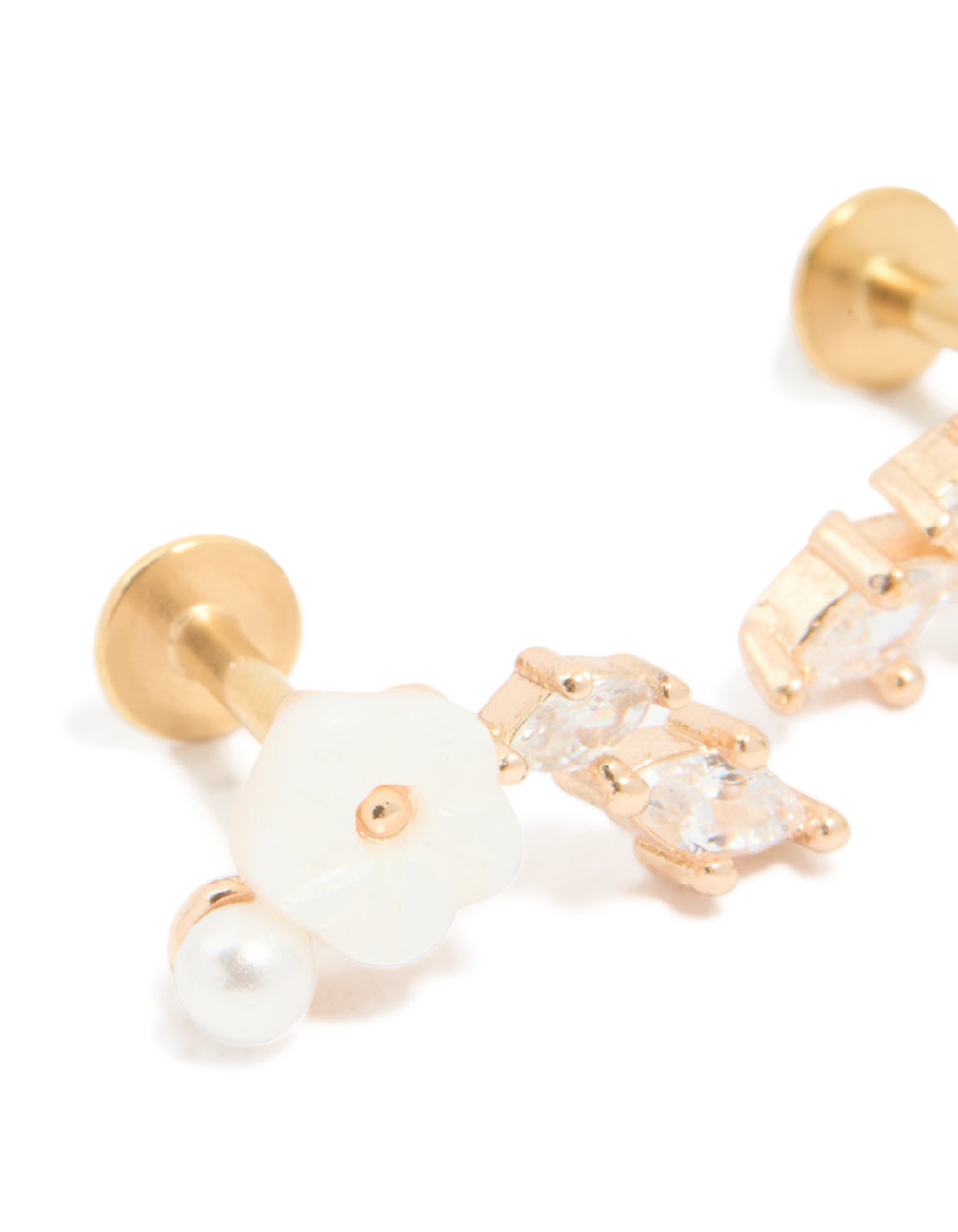 Featuring crawler style surgical flat back studs in gold plated material with floral and pearl accents close up view