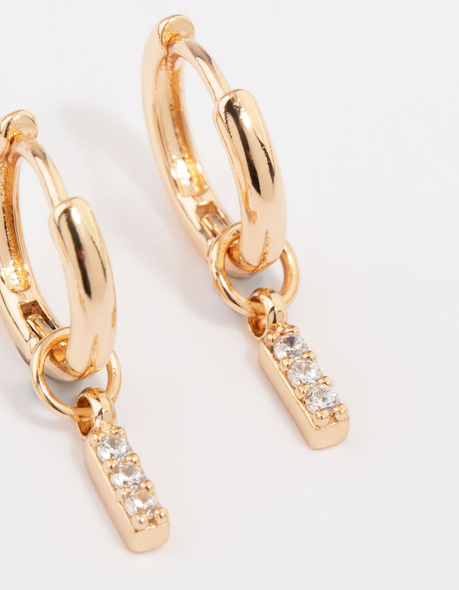 Elegant gold cubic zirconia heart and twisted huggie earrings in a 3-pack with bar and charm accents close up view