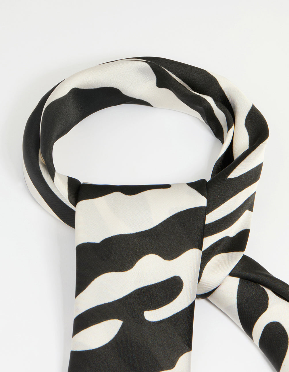 Crafted with zebra print fabric in black and white, this statement scarf side view
