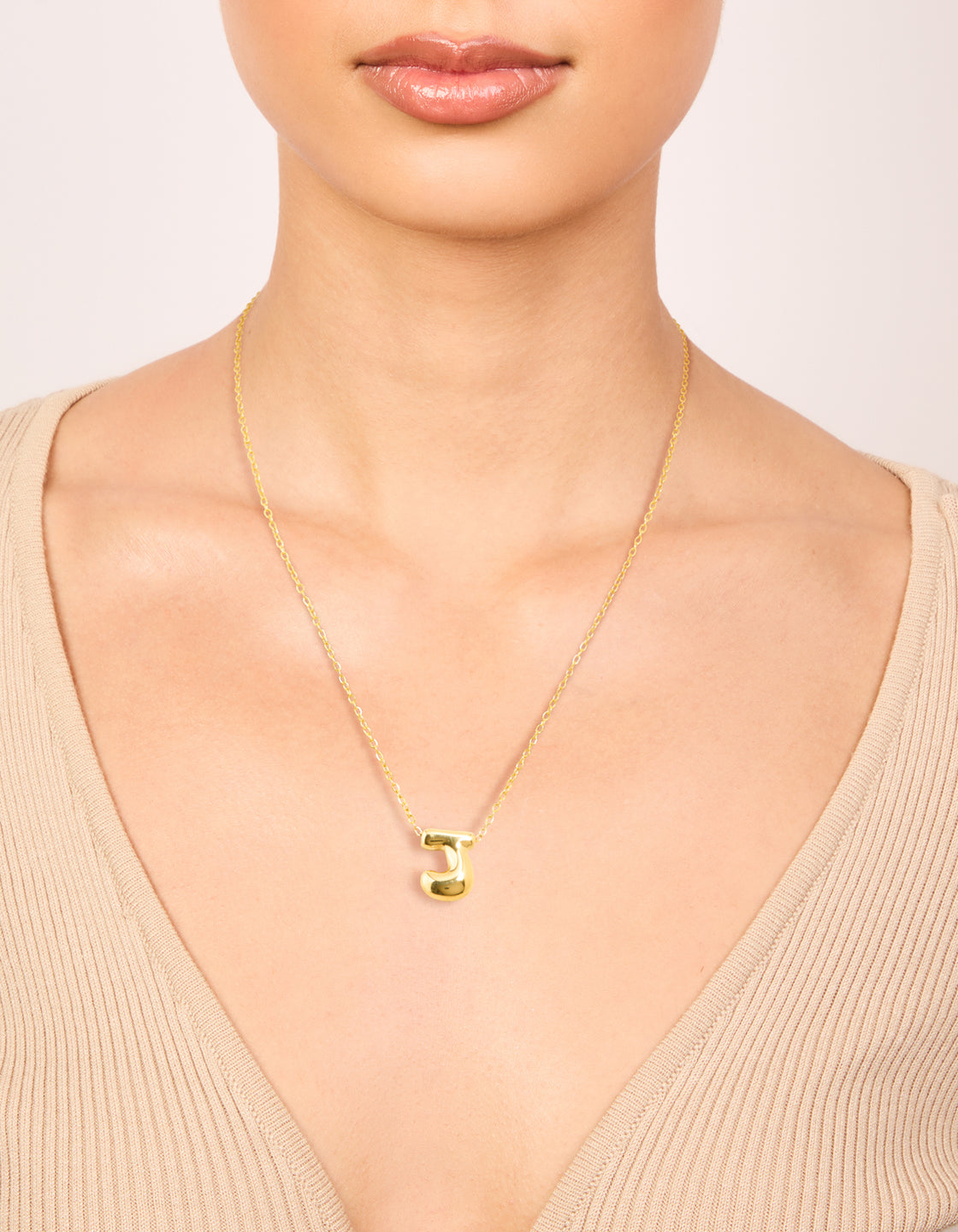 Crafted from waterproof gold plated stainless steel, this large bubble letter J necklace featuring initial pendant on neck view