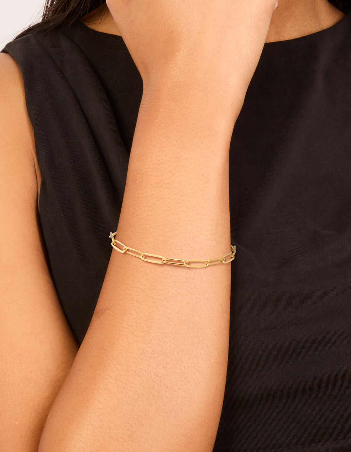Showcasing a waterproof gold plated stainless steel open oval link chain bracelet on wrist view
