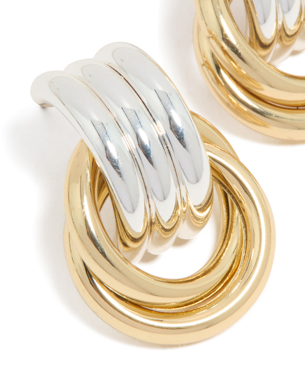Highlighting mixed metal plated doorknocker knot earrings in gold and silver close up view