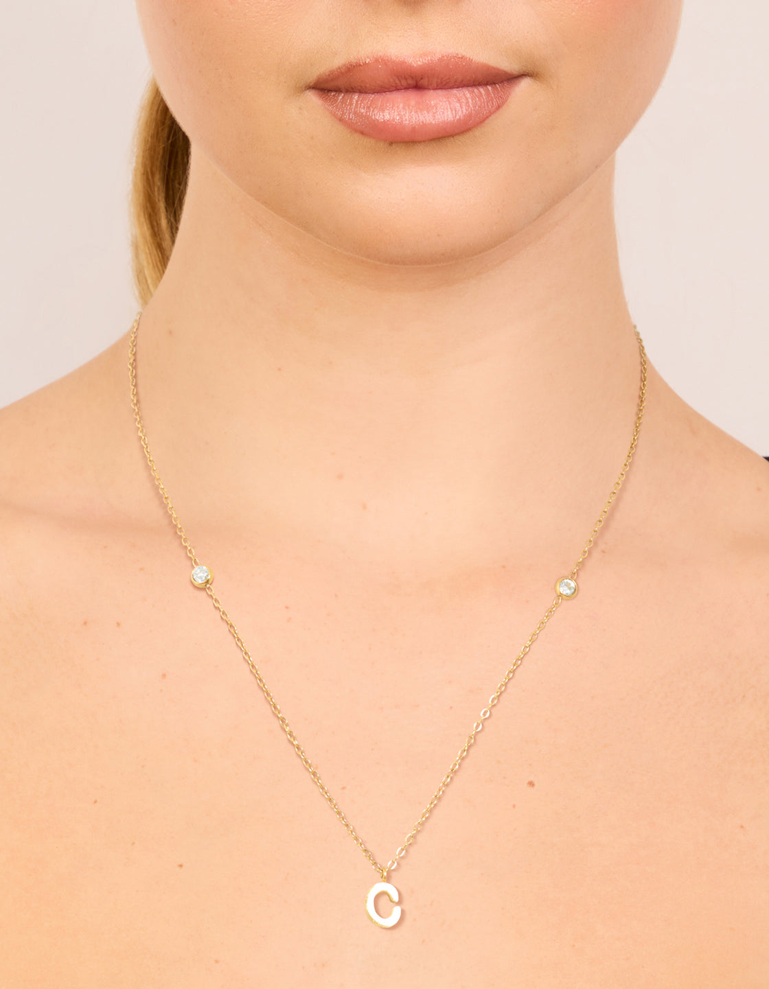 Showcasing a waterproof letter C pendant necklace in gold plated stainless steel with dainty styling on neck view