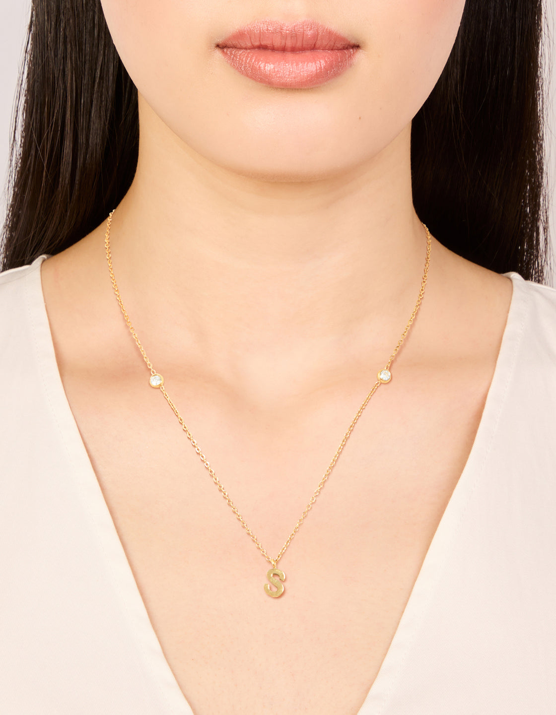 Showcasing a waterproof gold plated stainless steel letter S initial dainty pendant necklace on neck view