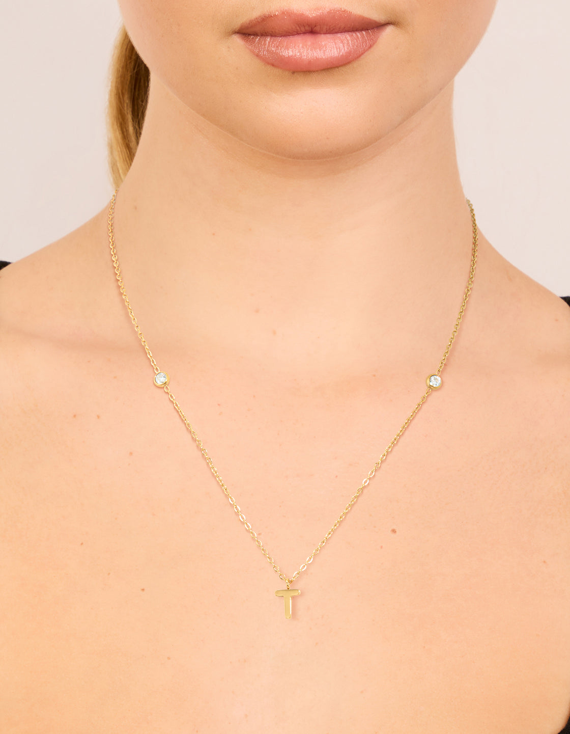 Featuring a waterproof letter T initial dainty pendant necklace crafted from gold plated stainless steel on neck view