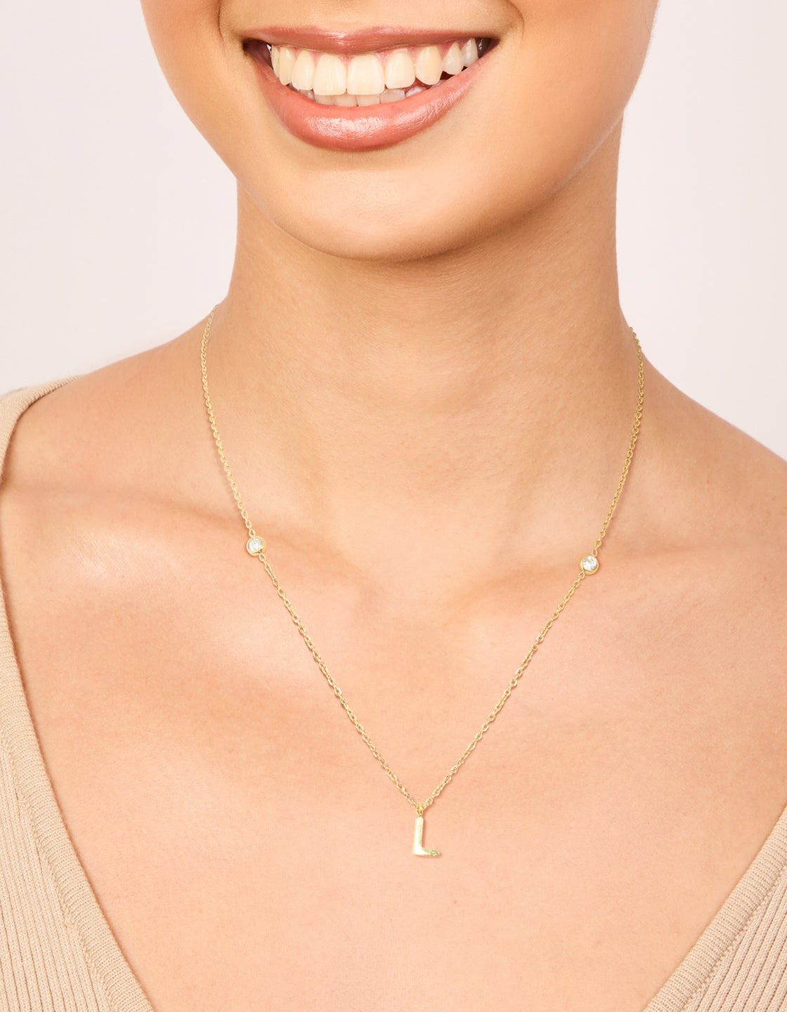 Designed with waterproof gold plated stainless steel, this dainty pendant necklace featuring beads and initial charm letter L on neck view