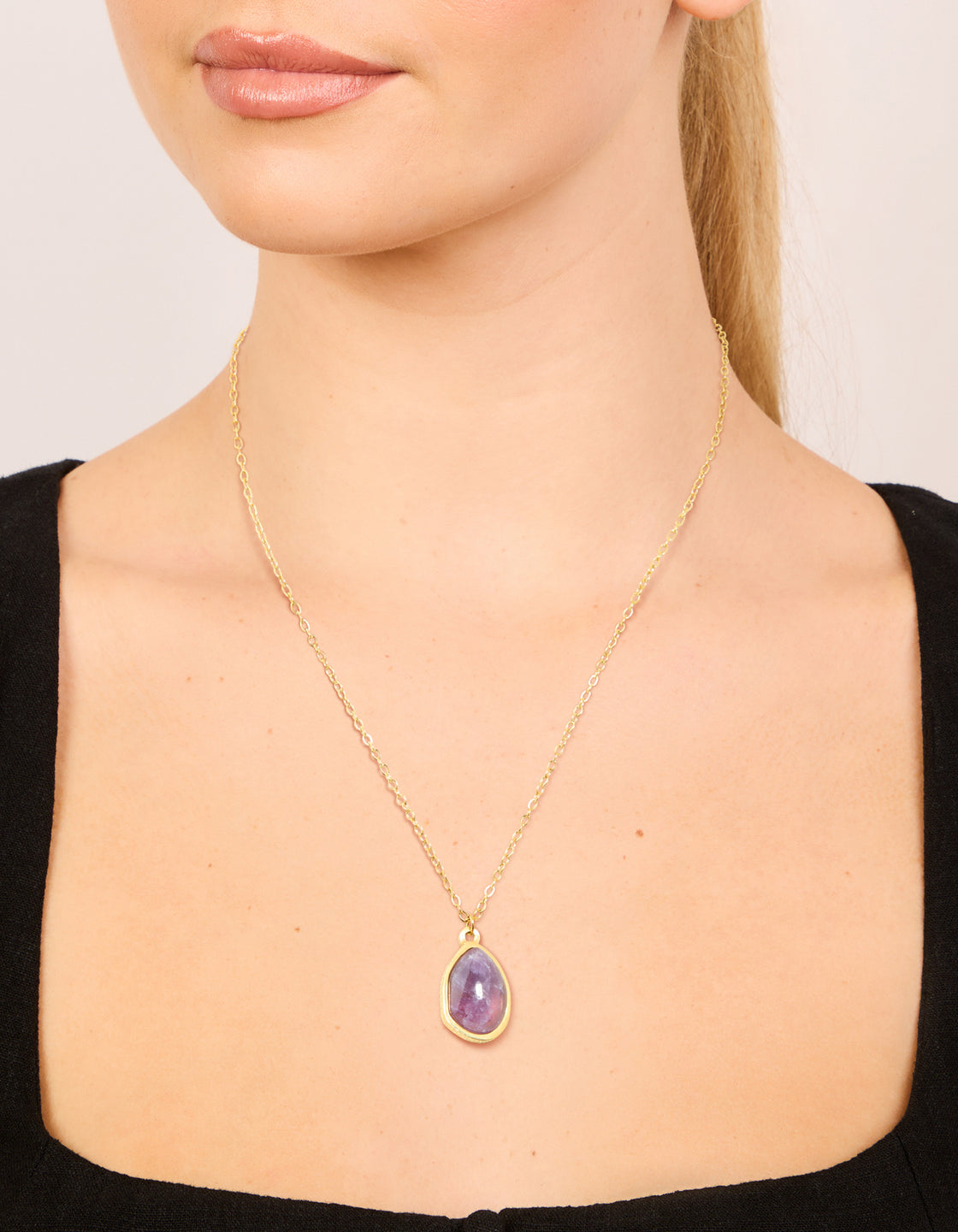Featuring a waterproof dainty necklace in gold plated stainless steel with amethyst pendant and purple color on neck view