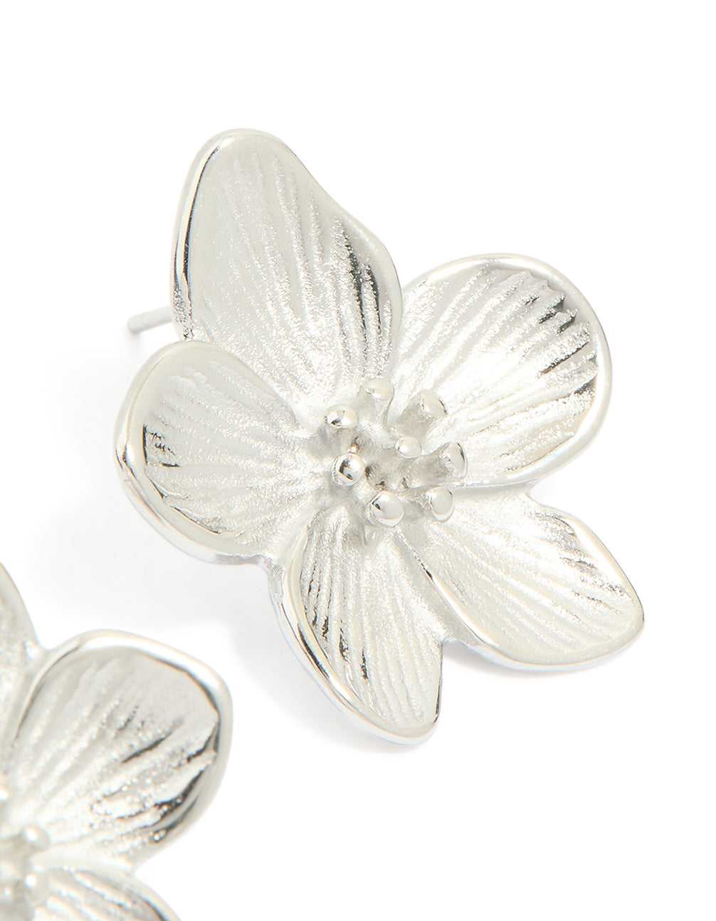 Highlighting mini textured flower earrings in waterproof stainless steel with floral pattern in silver post detail view