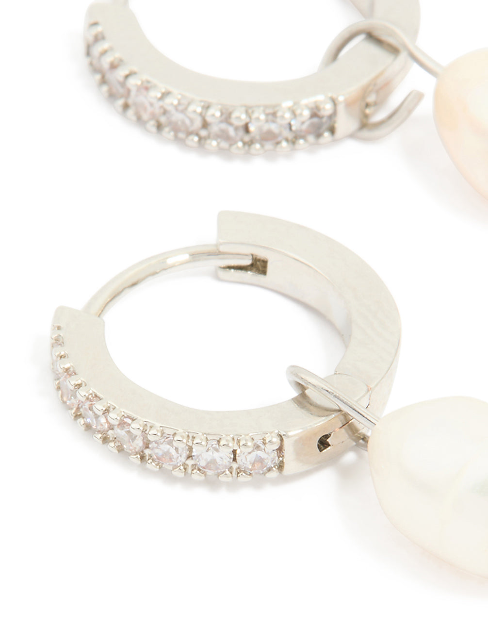 Detailed view of pearl drop huggie earrings with diamante detailing and waterproof stainless steel construction close up view
