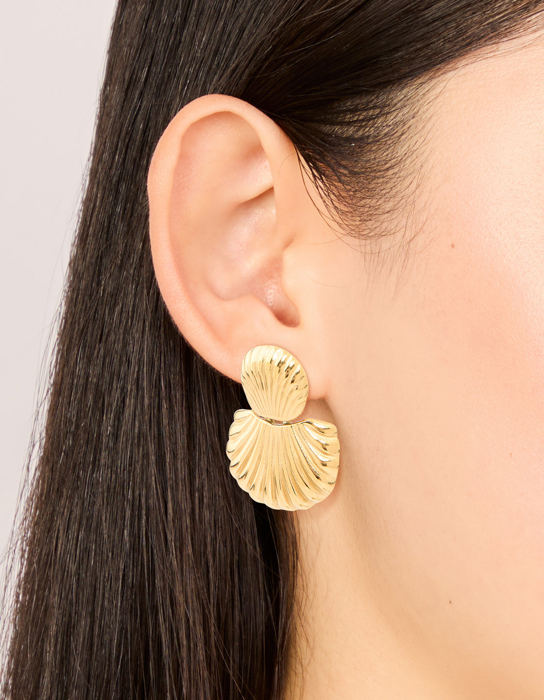 Elegant waterproof gold plated stainless steel double shell stud drop earrings with ocean-inspired design on ear view