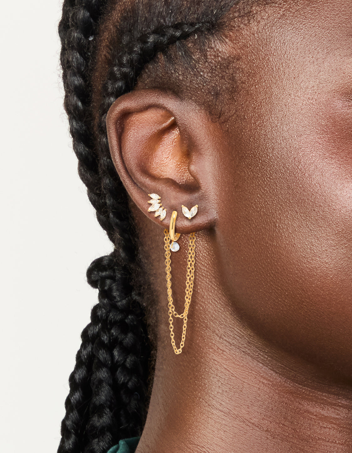 Showcasing waterproof stud earrings with marquise cubic zirconia stones in a 3-pack, crafted from gold plated stainless steel on ear view