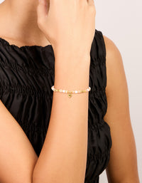 Showcasing a waterproof gold plated stainless steel rose quartz semi precious mini heart bracelet with beads, charm, and dainty styling on wrist view - link has visual effect only