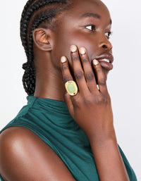 Elegant gold plated ring with oval pale green semi precious stone on finger view - link has visual effect only