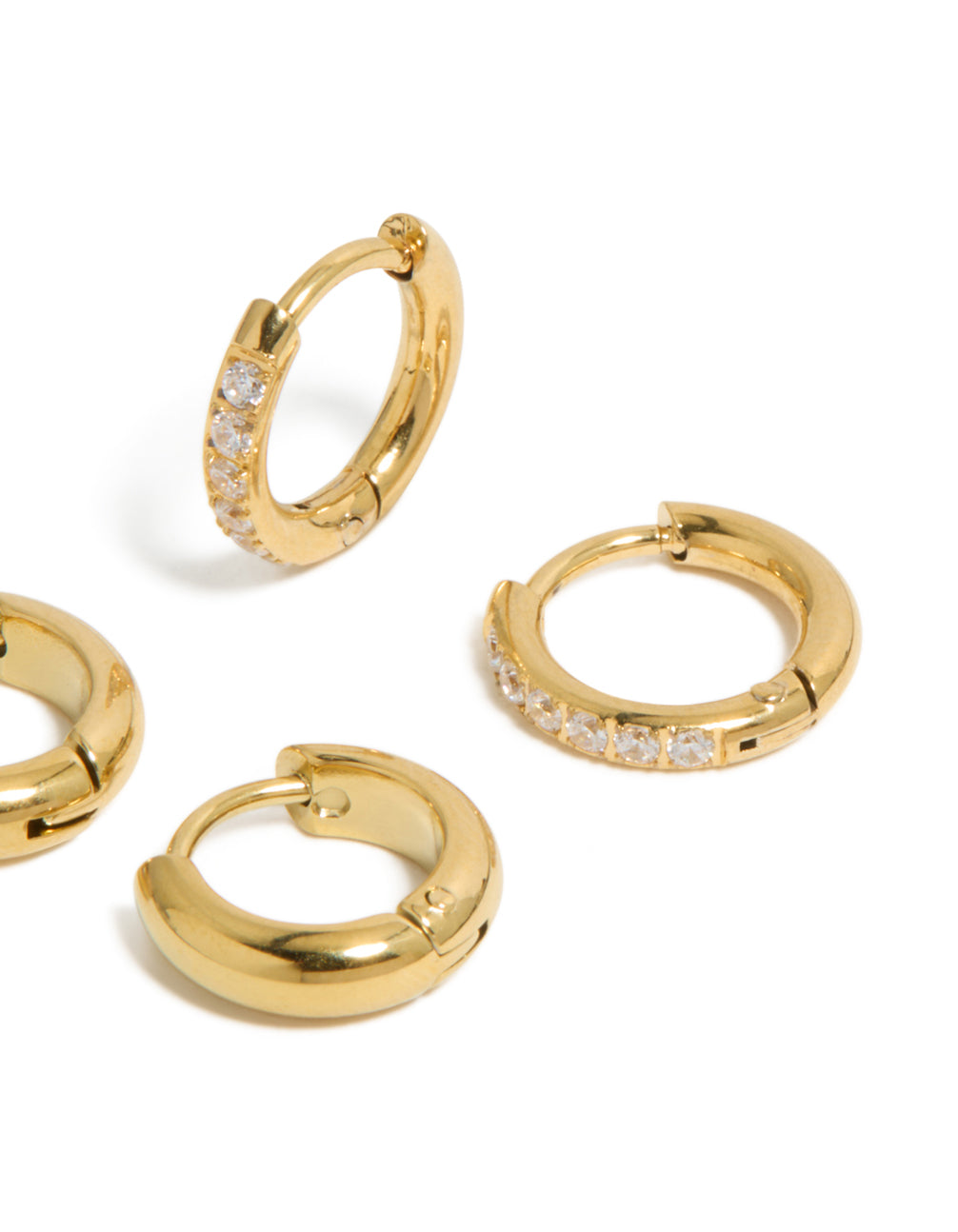 A detailed view of waterproof gold plated stainless steel cubic zirconia pavé and plain huggie earrings in a 2-pack post detail view