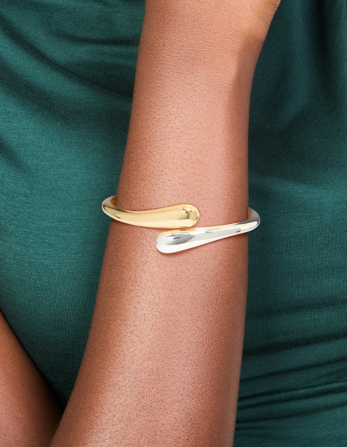 Crafted from gold and silver plated metal, this mixed wrap around bangle showcases a sleek design on wrist view