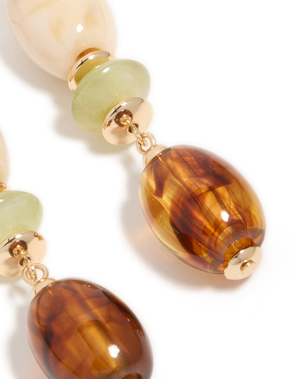 Close up of gold and acrylic mixed size beaded drop earrings highlighting pale green and dark brown texture post detail view