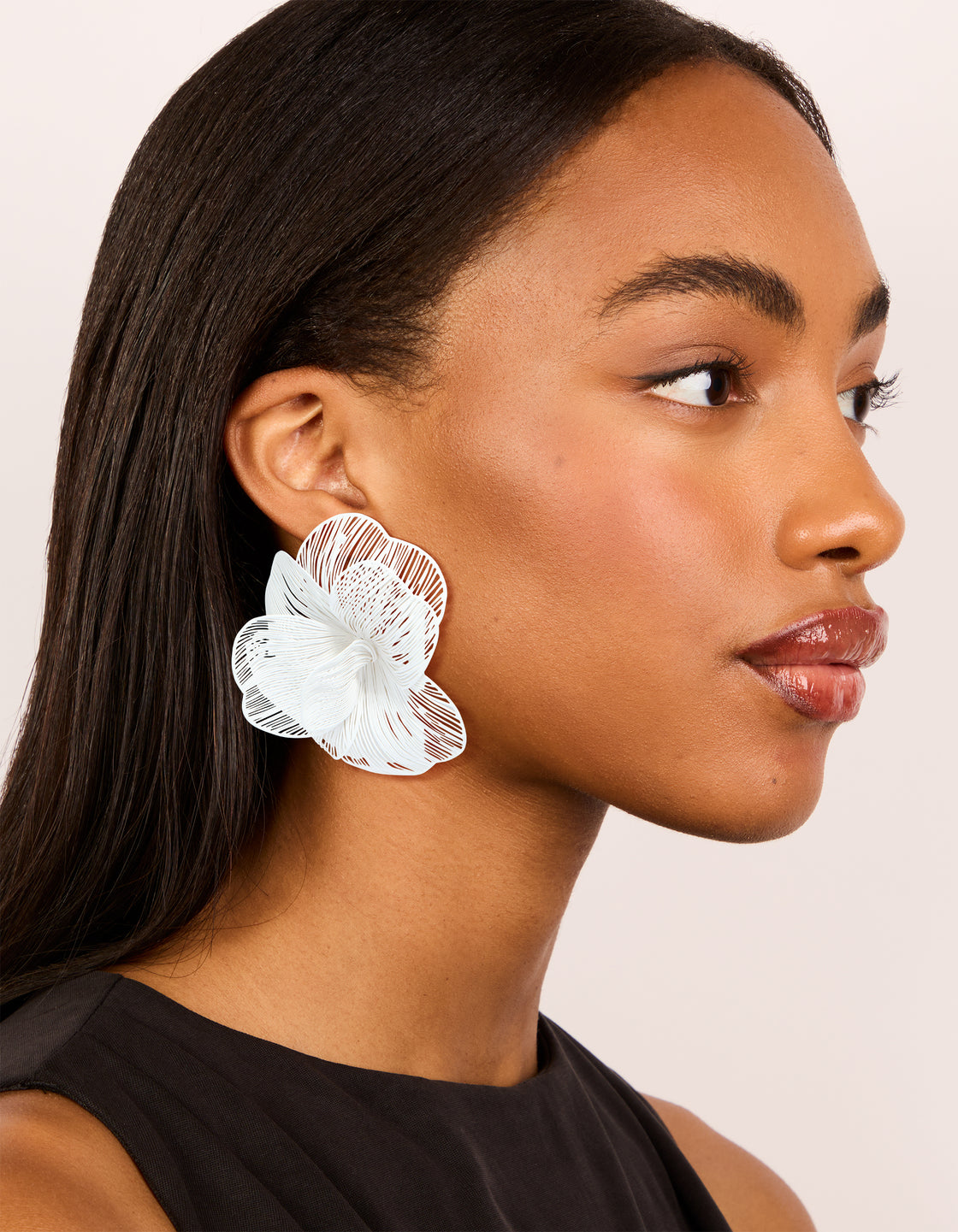 Crafted from white coated metal full flower stud earrings featuring floral pattern in ivory on model view