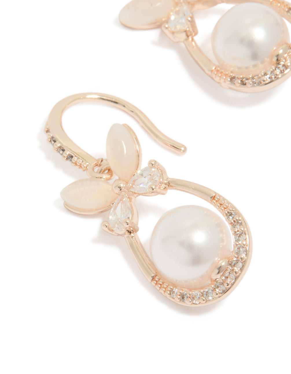Featuring white pearl center surrounded by cubic zirconia in oval cut, butterfly charm hook earrings with rose gold plated finish close up view