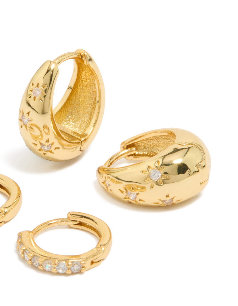Displaying statement celestial star and crystal cubic zirconia huggie earrings in a 2-pack, crafted from gold plated brass close up view
