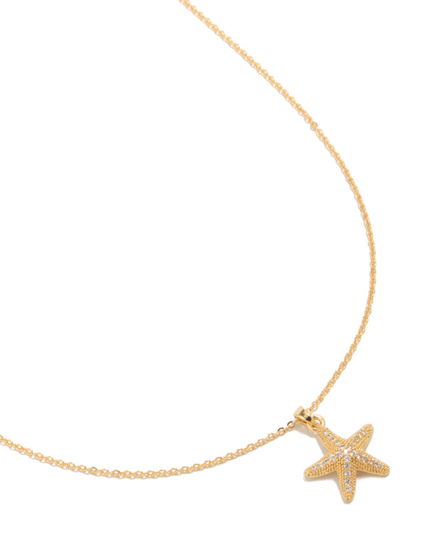 Showcasing a gold plated brass pavé cubic zirconia starfish pendant necklace with ocean inspired design close up view