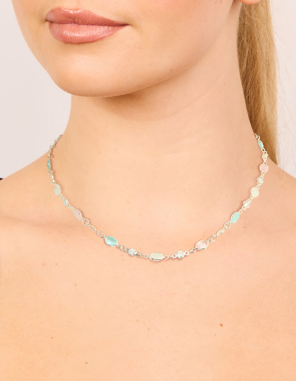 Showcasing a silver plated pink and blue cubic zirconia mixed oval necklace on neck view