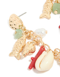 Shop gold fish drop earrings with ocean-inspired animal charms, shell accents, pearls, and beads in coral and mint cream in a close up view - link has visual effect only