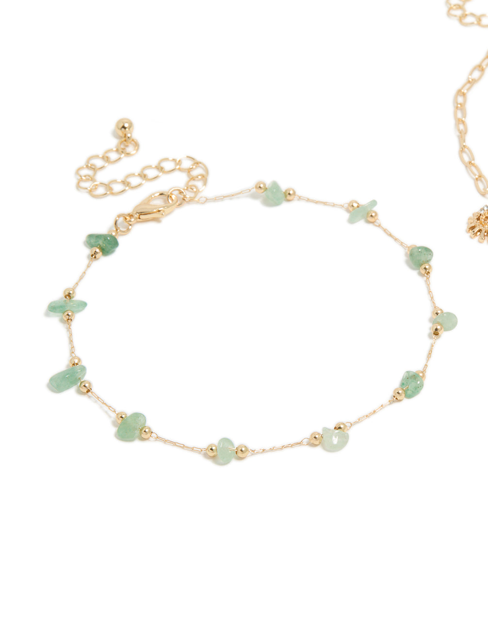 Crafted from gold, this semi precious stone and sea charm anklet 2-pack showcases beads with shell and sun accents in a ocean-inspired anklets detail view