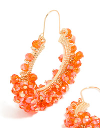 Showcasing statement hoop earrings with beads in coral and gold accessories close up view - link has visual effect only