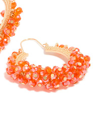 Highlighting statement hoop earrings adorned with beads in coral and gold accessories post detail view - link has visual effect only