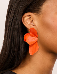 Showcasing orange coated metal flower petal drop earrings with floral design on ear view - link has visual effect only
